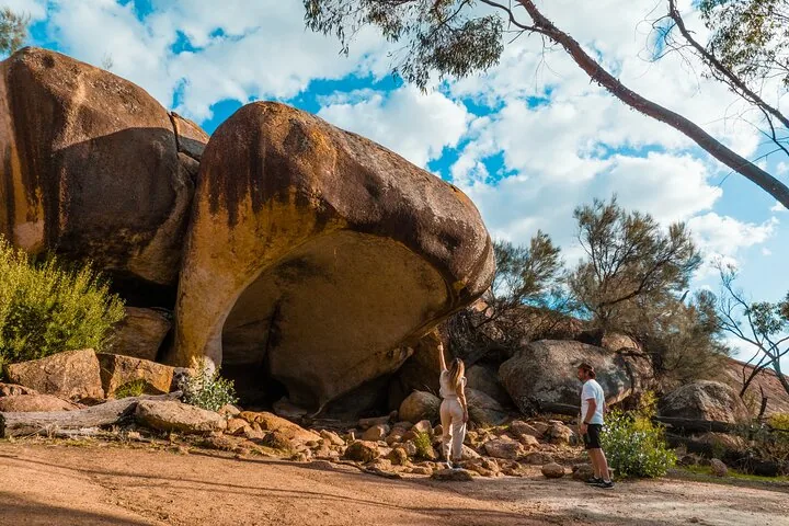 Two people exploring a large, overhanging rock formation known as Hippo's Yawn.